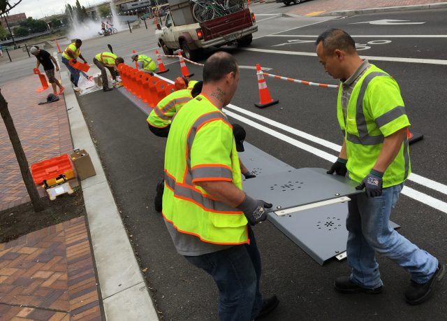 Crews are working overtime to get the final stations installed. This crew worked fast on Salmon Street on Saturday.(Photo: J. Maus/BikePortland)