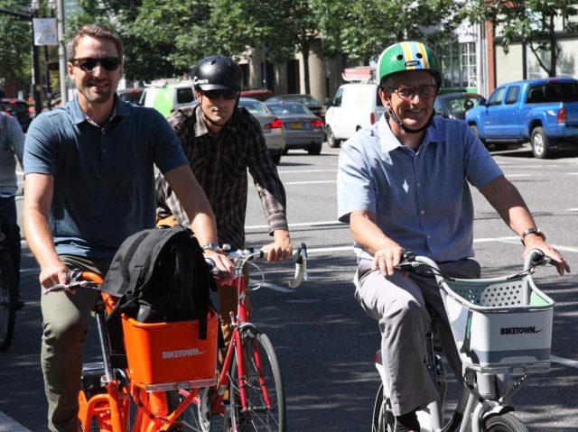 Mayor Hales (right) riding a Biketown bike on Naito Parkway this morning. (Photo: City of Portland) 