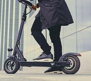 Close up image of a man on an electric scooter.