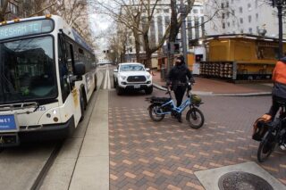 Bus, truck and bikes in an intersection.