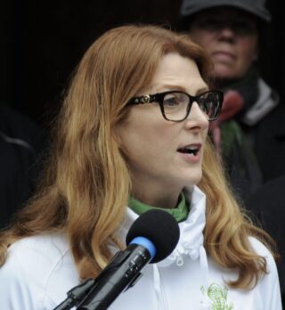 Person with red hair speaking into a microphone