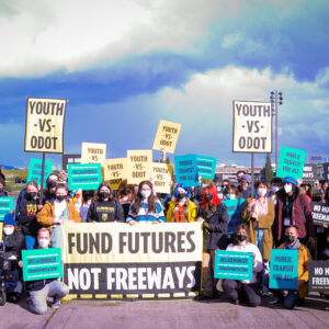 Group holding signs amid ominous clouds in background