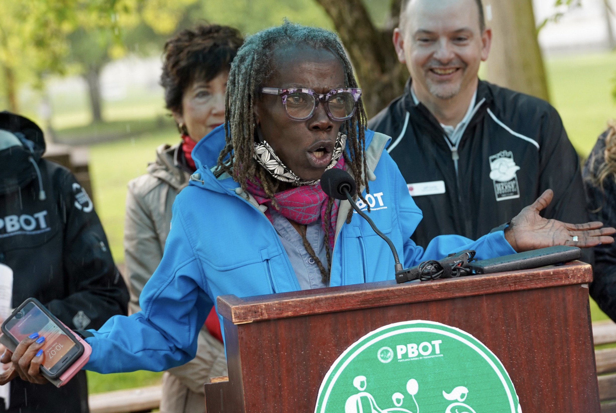 Jo Ann Hardesty wearing a blue jacket speaking at a lectern during a PBOT event.