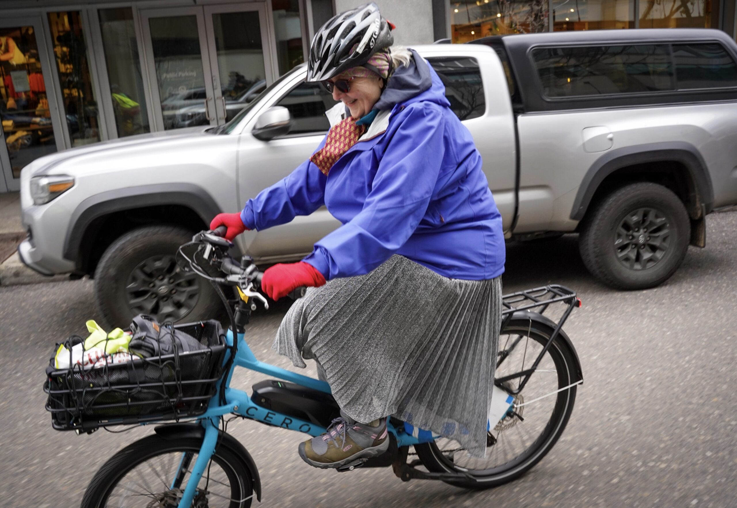 Person with a dress riding a bike on the street.