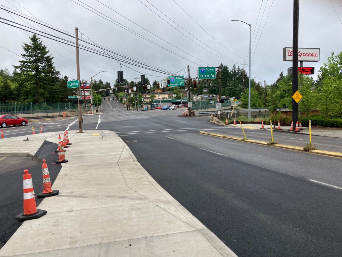 Photo of SW Capitol Highway at the intersection of SW Barbur, showing a recently poured concrete sidewalk.