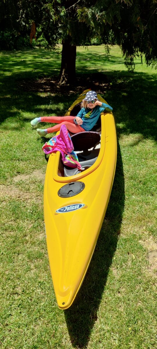 Yellow kayak with little girl sitting in it.