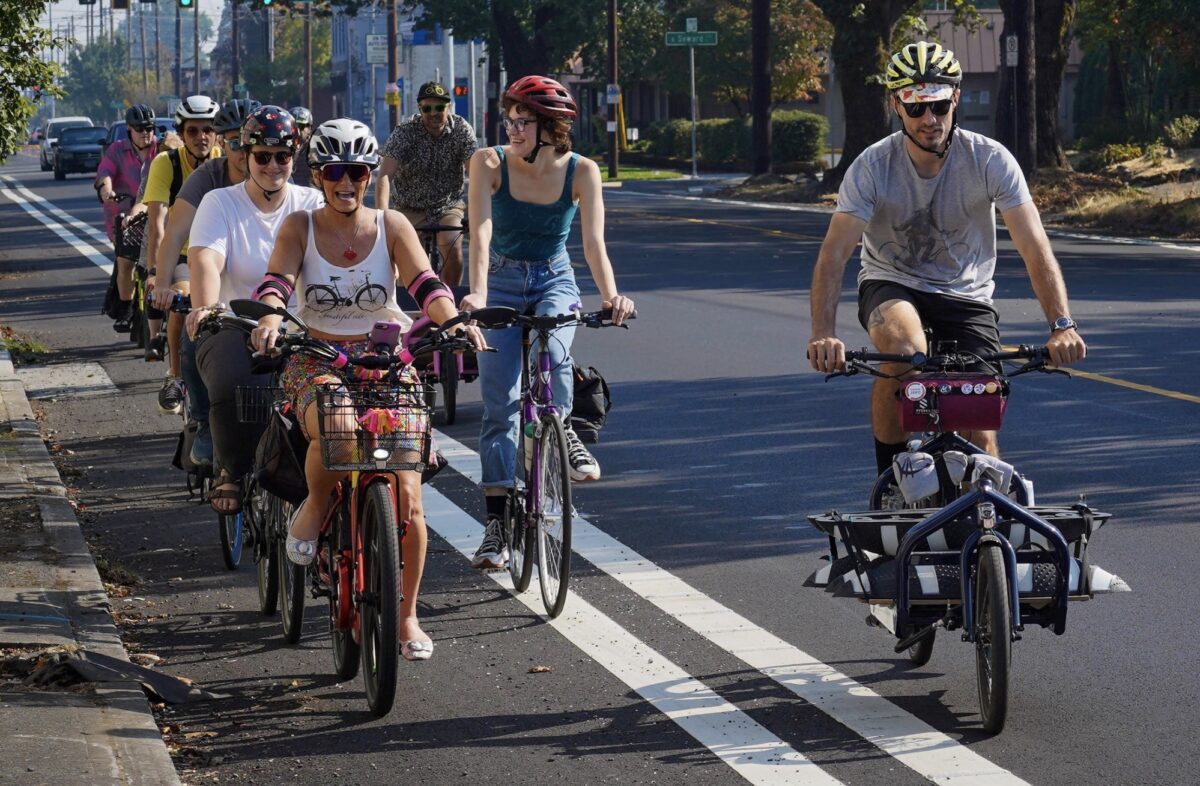 people biking in a bike lane together, some side by side